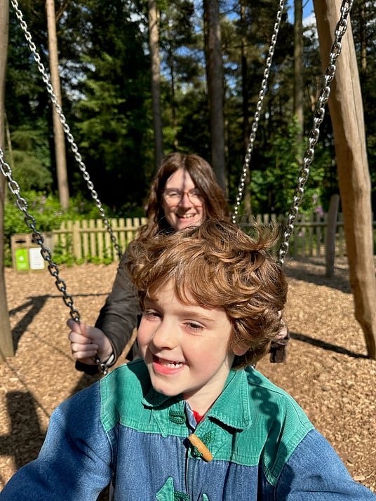 William sat on a log swing with his Mummy at Center Parcs.