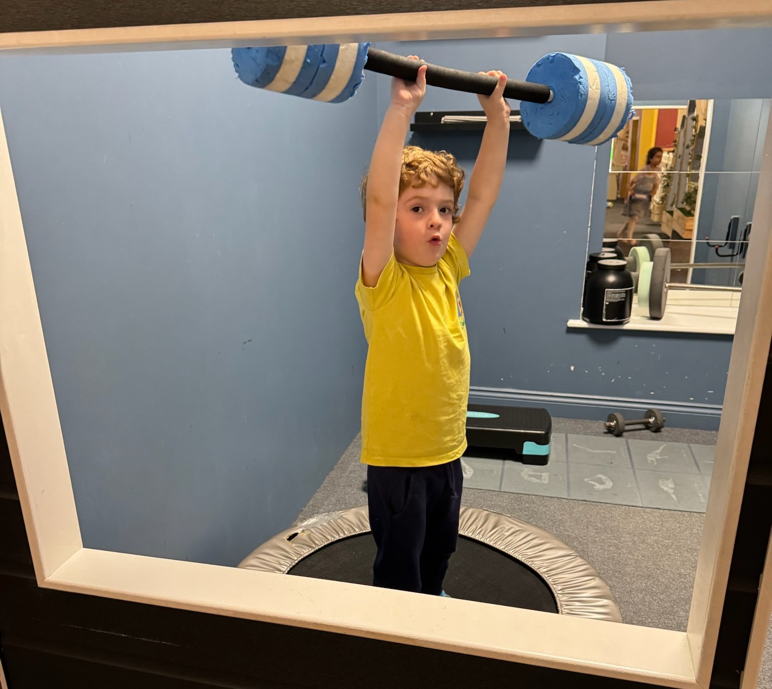 William lifting a foam barbell.